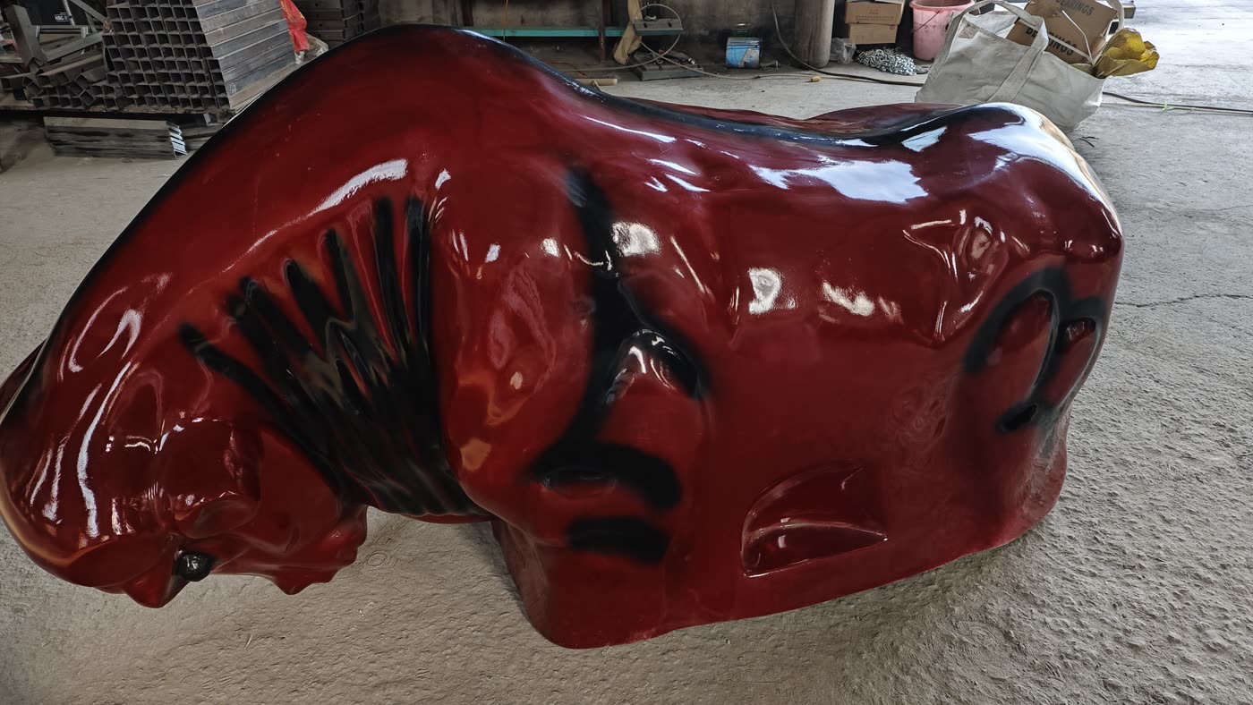 Red commercial mechanical rodeo bull, full side view in the workshop